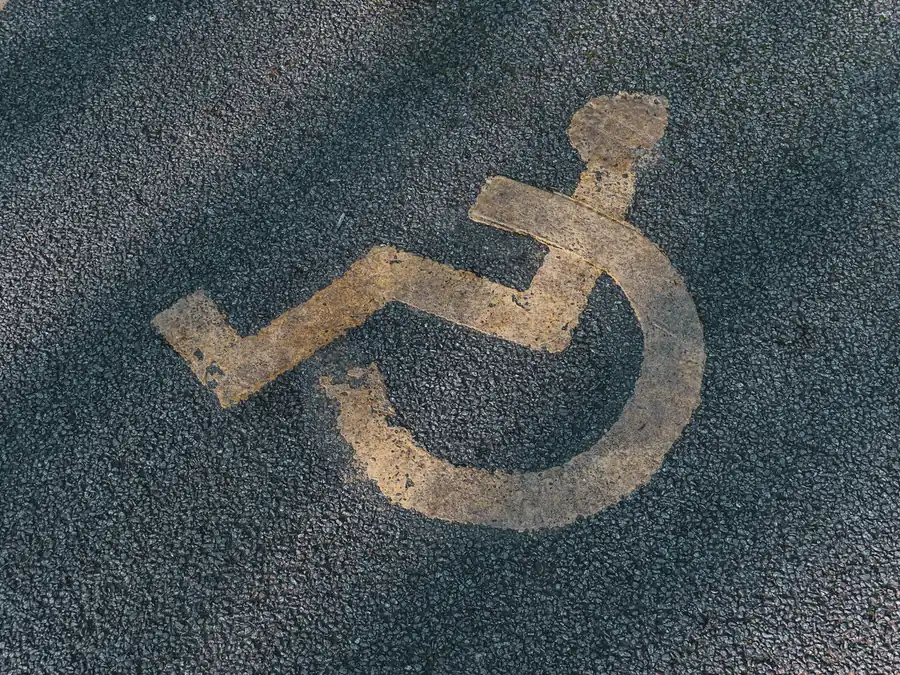 Worn accessible-parking symbol on asphalt