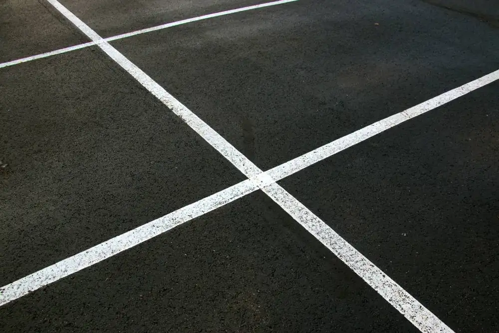 Fresh white stall lines on new asphalt